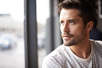 Image showing Handsome man, thinking and vision by window at cafe for ambition, travel or sightseeing. Face of male person waiting in wonder or thought at indoor restaurant or coffee shop for break or reflection