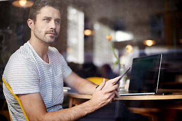 Image showing Young man, vision and laptop with phone at cafe by window for social media or communication at indoor restaurant. Male person on mobile smartphone in wonder for online chatting or app at coffee shop