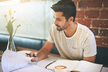 Image showing Man, paperwork and coffee shop with documents in planning, reading or finance at indoor restaurant. Male person or freelancer checking financial budget, journal or planner in notebook on desk at cafe