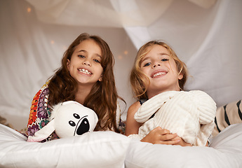 Image showing Happy, sleepover and portrait of children in bedroom for playing, bonding and relax with toys in home. Night, friends and young girls on bed in tent or blanket fort for childhood, fun and happiness