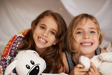 Image showing Happy, sleepover and portrait of kids in bedroom for playing, bonding and relax with toys in home. Excited, friends and young girls on bed in tent or blanket fort for childhood, fun and happiness