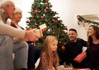 Image showing Family, present and christmas at home with love, giving and care together at holiday event. Happy, smile and tree with celebration, child and marriage in a house with grandparents and festive gift