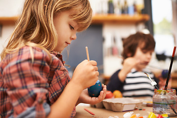 Image showing Child, paint and brushing egg with colorful art for learning, education or creativity at home. Young girl enjoying color, activity or artwork in early childhood development with sibling at the house