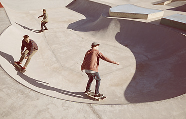 Image showing Fitness, friends and sports men with skateboard, ramp or bowl action at skate park for stunt training. Freedom, adrenaline and gen z skater people with energy, balance or skill, fun or performance