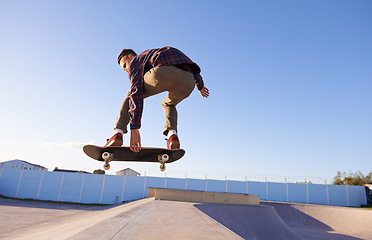 Image showing Sports, fitness and man with skateboard, jump or ramp action at a skate park for stunt training. Freedom, adrenaline and gen z male skater with energy, air or skill practice, exercise or performance