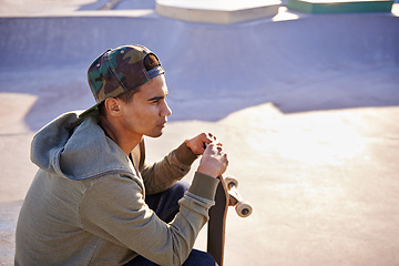 Image showing Thinking, skateboard and man at a skate park with idea for trick, stunt or adrenaline sports action. Planning, calm and male skateboarder with reflection, questions or memory while chilling on a ramp