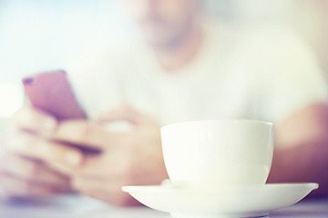 Image showing Man, hands and tea cup with phone at cafe for communication, morning or social media. Closeup of male person with drink or beverage on mobile smartphone for online chatting or texting at coffee shop