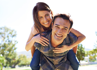 Image showing Portrait, piggy back and couple with love, outdoor and bonding together with romance and sunshine. Face, man carrying woman and summer with weekend break and marriage with fun, play and relationship