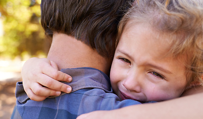 Image showing Hug, sad girl and father in a park, emotions and expression with reaction and crying with single parent. Loss, family and outdoor with dad and daughter with embrace and grief with tears, adhd or pain