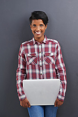 Image showing Happy woman, portrait and fashion with laptop in confidence on a gray studio background. Face of young female person, Indian or freelancer with smile and computer in stylish clothing on mockup space