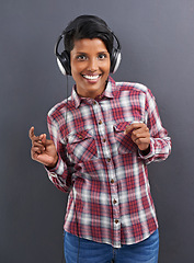 Image showing Happy woman, portrait and dancing with headphones for music or podcast on a gray studio background. Young female person or Indian with smile enjoying or listening to audio or sound track with headset