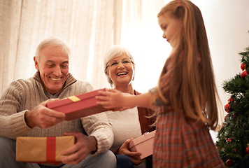 Image showing Family, christmas giving and gifts with kids and grandparents together with tree in living room. Home, happy and present with holiday and celebration at a party with love, care and bonding with smile