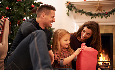 Image showing Family, christmas tree and gift wrapping with kids, parents and box together with giving in living room. Home, happy and present with holiday and celebration at a party with love, care and bonding