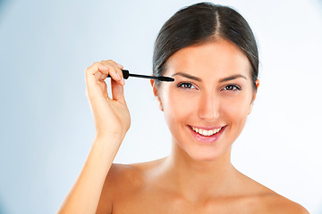 Image showing Brush, mascara and woman in portrait with makeup for beauty, transformation and lashes on white background. Face, smile and hand with wand for eyelash change, tools and cosmetic product in studio