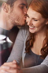 Image showing Happy couple, kiss and love with embrace for support, intimacy or affection together at indoor cafe. Man and woman with affection on cheek for date, relationship or romantic bonding at coffee shop