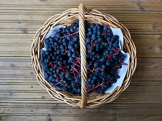 Image showing bunches of  blue ripe grapes in a wicker basket