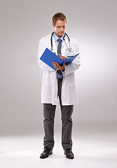 Image showing Clipboard, doctor and man in studio writing notes for medical research, insurance and report for hospital. Healthcare, clinic and worker with documents for consulting and planning on gray background