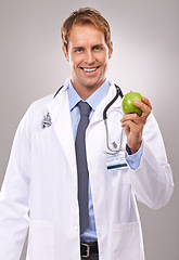 Image showing Man, doctor and apple in studio portrait, medical expert and dietician on gray background. Happy male person, fruit and proud of choice or decision for nutrition, vitamins and minerals for health