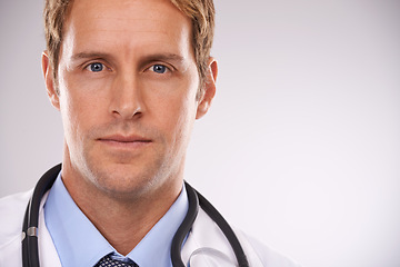 Image showing Doctor, man and portrait in studio for health, medic or diagnosis with stethoscope for job on mockup. Young person or expert and serious and confident for career, medicine and specialist for medical