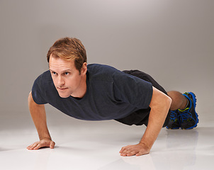 Image showing Man, face and push up with fitness or workout in studio with exercise, serious and training with confidence. Athlete, person and physical activity on gym floor for healthy body on black background