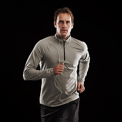 Image showing Earphones, runner or man running in studio for training, cardio exercise or workout for health wellness. Male person, fitness or sports athlete on black background to jog with radio, music or podcast