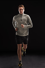 Image showing Man, portrait and cardio running in studio for athlete performance or marathon, training or black background. Male person, face and fitness sports with mockup space for health, workout or exercising