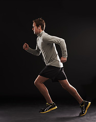 Image showing Headphones, profile or man running in studio for training, cardio exercise or workout for health wellness. Side view, fitness or sports athlete on black background to jog with radio, music or podcast