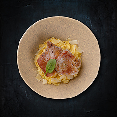 Image showing Juicy pork chops on a bed of pasta