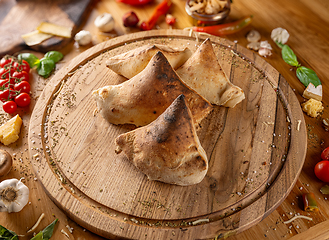 Image showing Delicious calzones on a wooden board