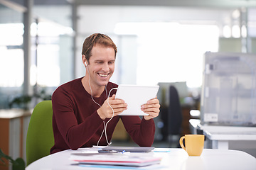 Image showing Tablet, smile and businessman with earphones, watching and desk in office workplace. Happy, technology and entertainment business videos or streaming, creative and internet research for project