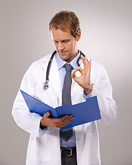 Image showing Clipboard, doctor and man in studio with okay sign for medical research, insurance and good news. Healthcare, hospital and worker with hand gesture for consulting, yes and planning on gray background