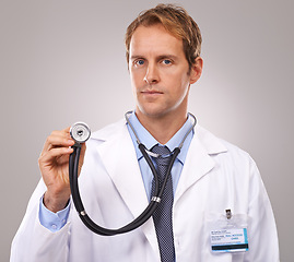 Image showing Stethoscope, doctor and portrait of man in studio for medical research, consulting and wellness. Healthcare, hospital and worker with equipment for cardiology, service and help on gray background