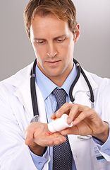 Image showing Man, doctor and pills bottle in studio, medicine and pharmacist on gray background for healthcare. Male person, capsule or tablets for virus treatment, drugs and medication for medicare or vitamins