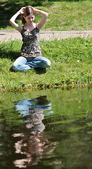 Image showing girl sits near lake