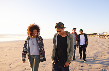 Image showing Travel, beach and friends walking in nature for vacation, bonding or holiday outdoor together at sunset. Happy, journey and gen z group of people at sea for fresh air, conversation or ocean adventure