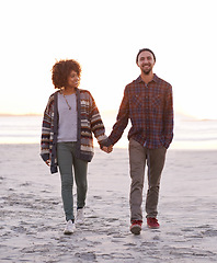 Image showing Couple, smile and walking together on beach, happy calm people on vacation. Ocean, outdoor and partners in love with respect and care, date and romantic stroll for relax with seaside sunrise
