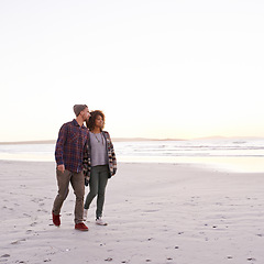 Image showing Couple, beach and walking together in nature, happy calm people on vacation. Ocean, outdoor and partners in love with respect and care, date and romantic stroll for relax with seaside sunrise