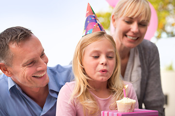 Image showing Girl, blowing or candle at happy birthday, party or cake as fun wish, family or bonding together. Papa, mama or child or smile at celebration, congratulations or childhood growth and development