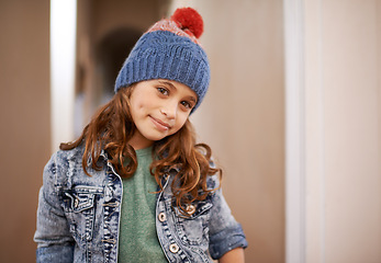 Image showing Girl, portrait and child with fashion in winter at home with pride and happiness in clothes with hat. Kid, smile or relax in house with beanie, jacket or casual style on holiday or vacation in Sweden