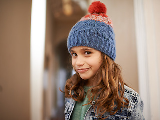 Image showing Girl, portrait and child with fashion in winter at home with pride and happiness in clothes with hat. Kid, smile or relax in house with beanie, jacket or casual style on holiday or vacation in Sweden