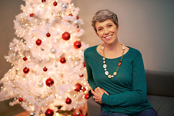 Image showing Christmas, tree and portrait of mature woman in home for holiday, festival or celebration on vacation. Happy, person and relax on sofa with festive xmas decoration in living room and enjoy retirement