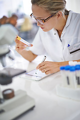 Image showing Woman, laboratory and writing with vial for experiment, test or exam in laboratory research or discovery. Female person or medical professional reading capsule, information or symptoms of drug at lab