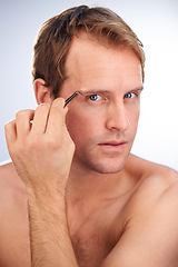 Image showing Man, portrait and tweezers for eyebrow in studio or hair removal cleaning for grooming, skincare or mockup space. Male person, face and tool for wellness or plucking, dermatology on white background