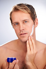 Image showing Man, portrait and skincare cream or product for moisturiser routine or dermatology, transformation or studio. Male person, face and wellness as hygiene lotion for facial, white background or mockup