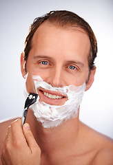 Image showing Man, portrait and shaving cream with razor for beard hair removal or grooming, maintenance or white background. Male person, face and smile with tool for dermatology cleaning, studio or mockup space