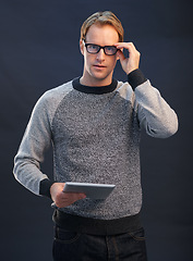Image showing Man, glasses and tablet in studio portrait with connection, contact and fashion by dark background. Person, nerd or geek with digital touchscreen, pride and confidence with app for social network