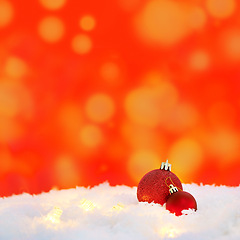 Image showing Christmas, lights and balls for decoration on snow with mockup space in winter on a red background. Xmas, ice and festive sphere, bauble and ornaments for christian holiday celebration at a party