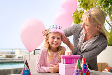 Image showing Portrait, girl or mom at happy birthday, party or cake in box, gift or hat at poolside patio table. Mama, child or smile at crown, candle or balloon to love, care or celebrate as childhood wish
