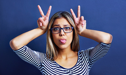 Image showing Studio, funny faces and woman with peace sign on hands for promo or deal for clothes in fashion. Adult, female person and girl in blue background with glasses or eyewear, aesthetic and portrait