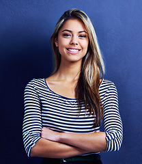 Image showing Portrait, confidence and happy business woman in studio isolated on a blue background. Arms crossed, female person and creative entrepreneur or professional designer in casual clothes in Switzerland